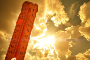 Melting street thermometer against bright summer sun.High temperature.Summer heat.Concept of global warming
